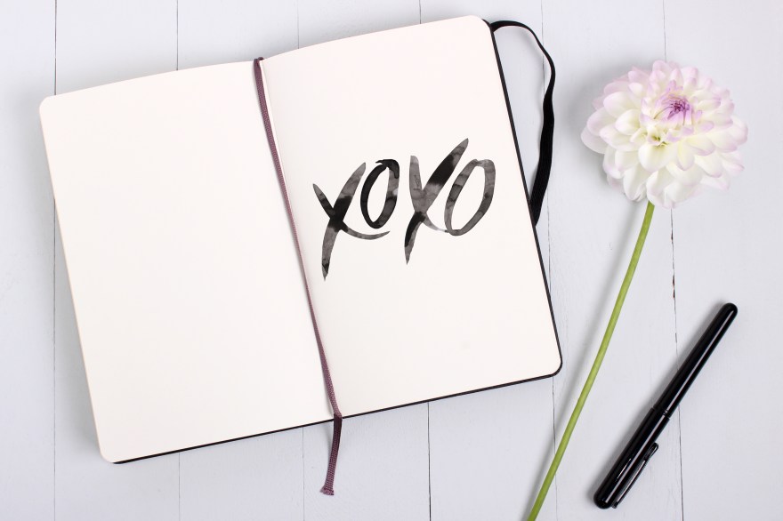 Sketchbook mockup with pen and flower